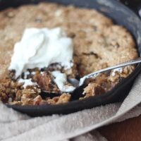 Side angle of Maple Oatmeal Raisin Skillet Cookie with Greek Yogurt dug in with a spoon