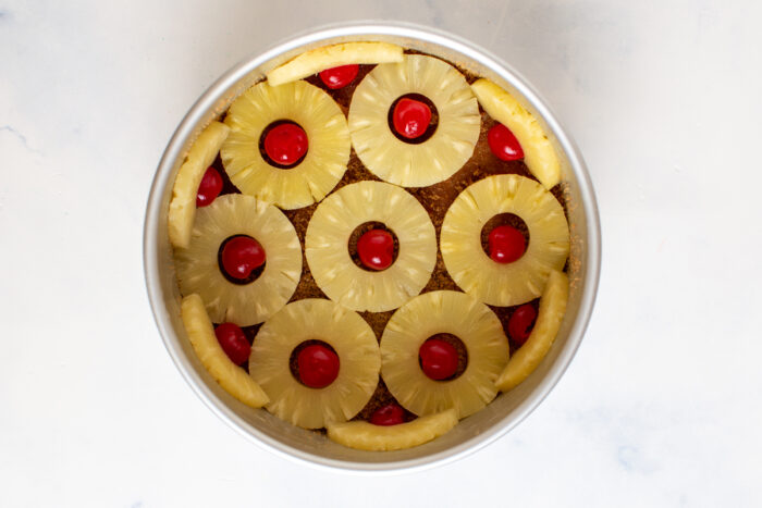 Pineapple rings and cherries decorating the bottom of the cake pan