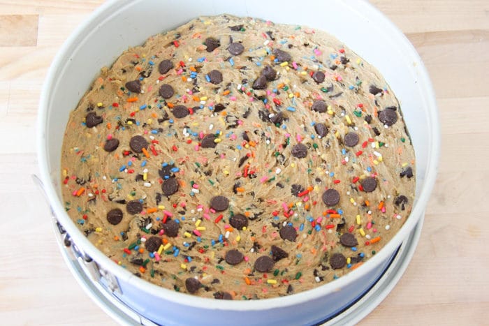Chocolate chip cookie cake dough in a 9 inch spring form pan before being baked