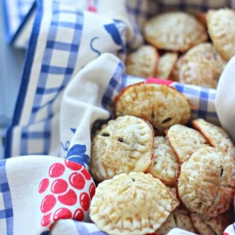 Mini Chocolate Hand Pies in a basket with a floral cloth