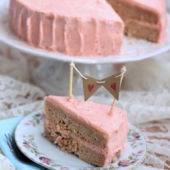 A slice of Strawberry birthday cake with strawberry vanilla bean icing