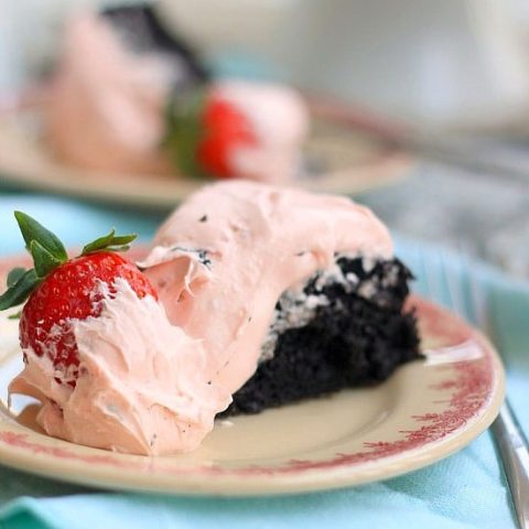 A slice of White Chocolate Covered Strawberry and Dark Chocolate Fudge Cake