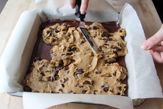 Spreading the cookie dough over the brownie batter for the brookies