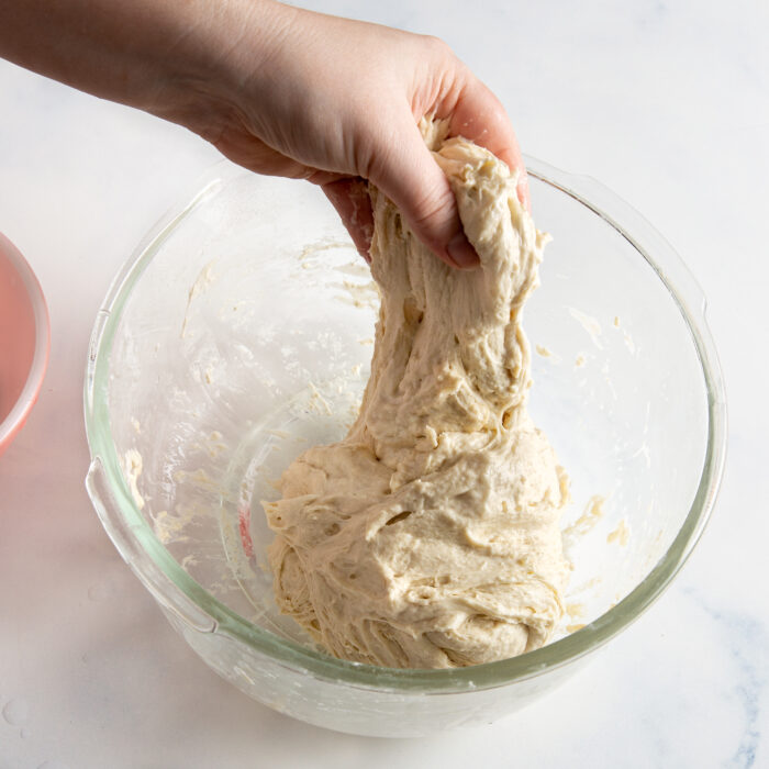 continuing to stretch the dough by hand