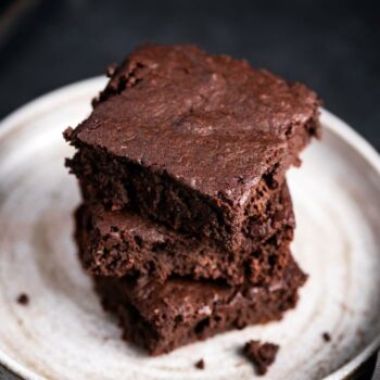 Plate of chewy brownies stacked up on eachother