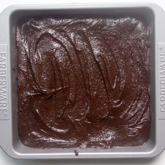 Raw brownie batter in square pan