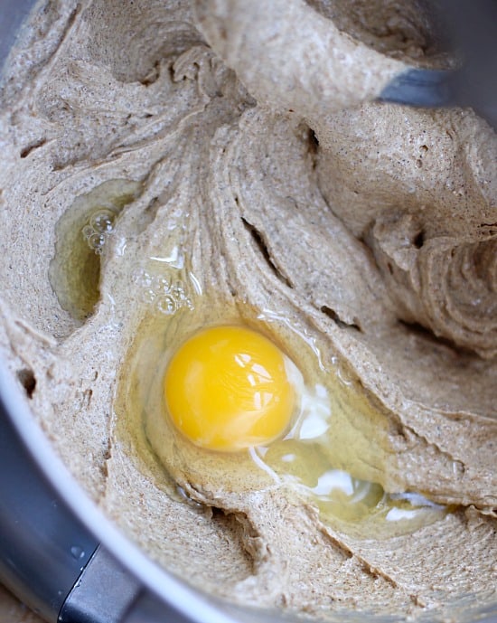 Adding eggs to the mixer with creamed butter and sugar.