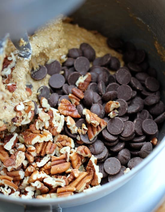 Cookie dough with pecans and chocolate chips inside a mixing bowl