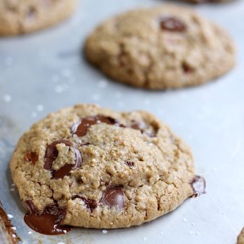 Ultimate chocolate chip cookies on a sheet pan after being baked. The chocolate is melting out of the cookies