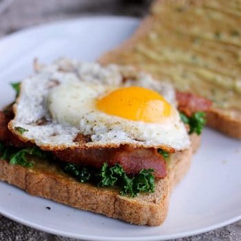 Kale, bacon and an over-easy egg with aioli on sliced bread