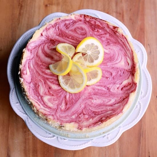 Raspberry Swirled Lemon Cheesecake with lemon slices as decoration on top