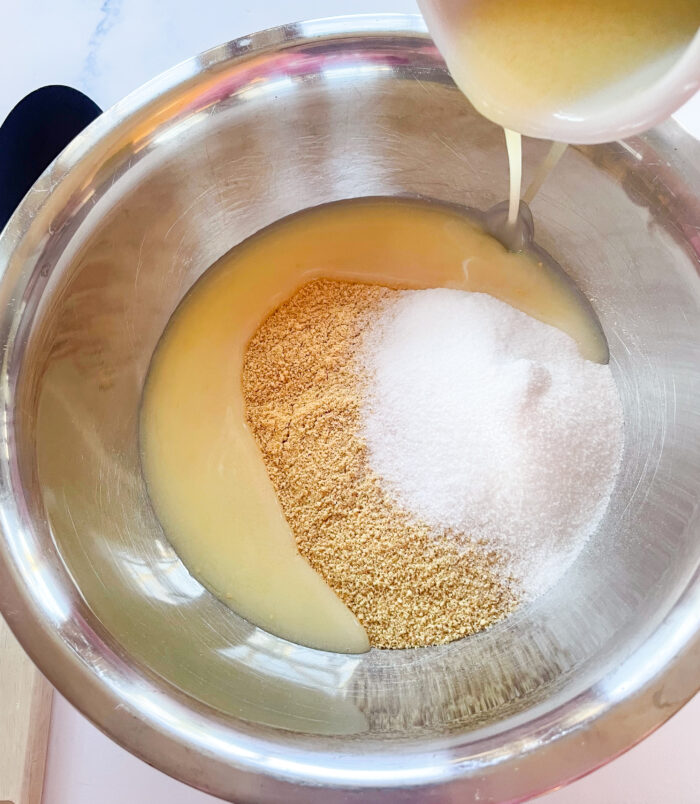 graham cracker crumbs, sugar, and melted butter being mixed together