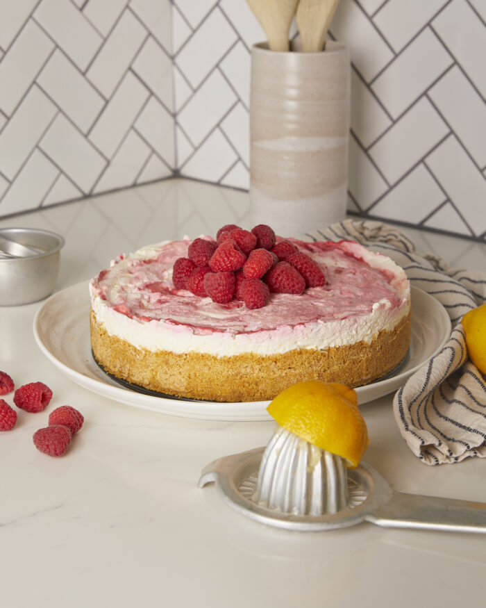 lemon raspberry cheesecake on a cake plate