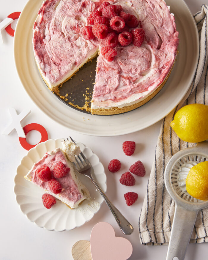 a slice of lemon raspberry cheesecake taken out and placed on a plate