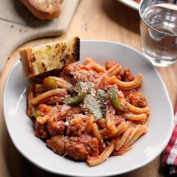 Spicy Sausage Pasta Marinara in a bowl with a slice of garlic bread