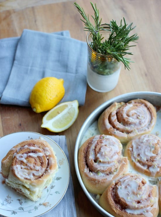 Rosemary Lemon Cinnamon Rolls in a pan drizzled with glaze