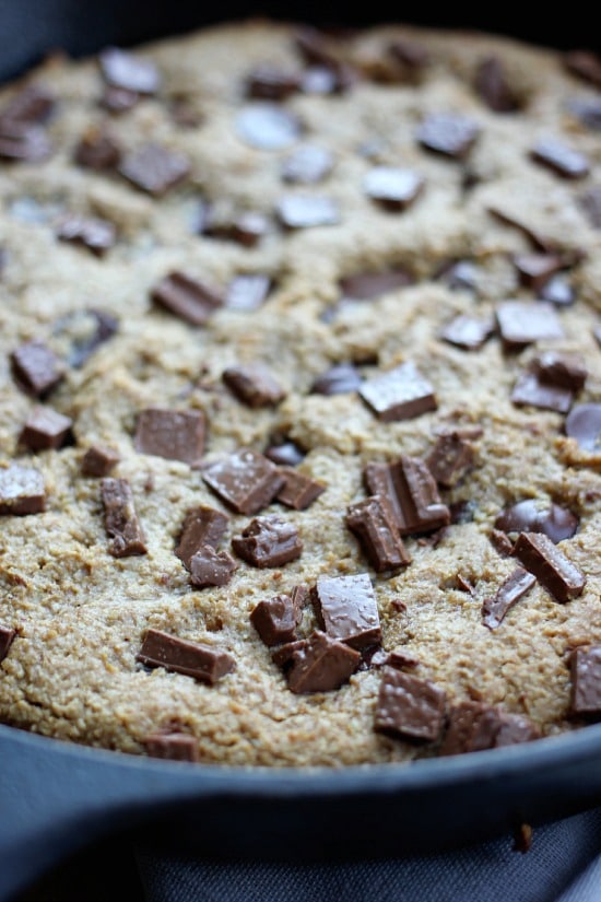 A closeup of the cookie in the skillet with chocolate chunks