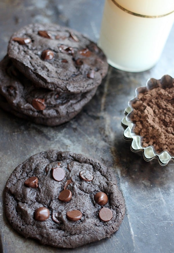 Spicy chocolate cookies on a sheet pan with a glass of milk