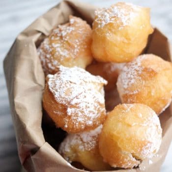 Pate a Choux Beignets in a paper bag sprinkled with powdered sugar