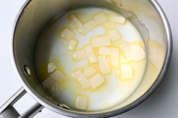 Water, milk and butter melting in pot