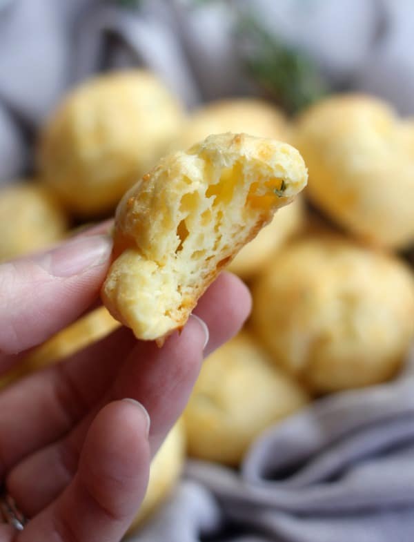 A bite taken out of a Sharp Cheddar and Thyme Cheese Puff (Gougère)