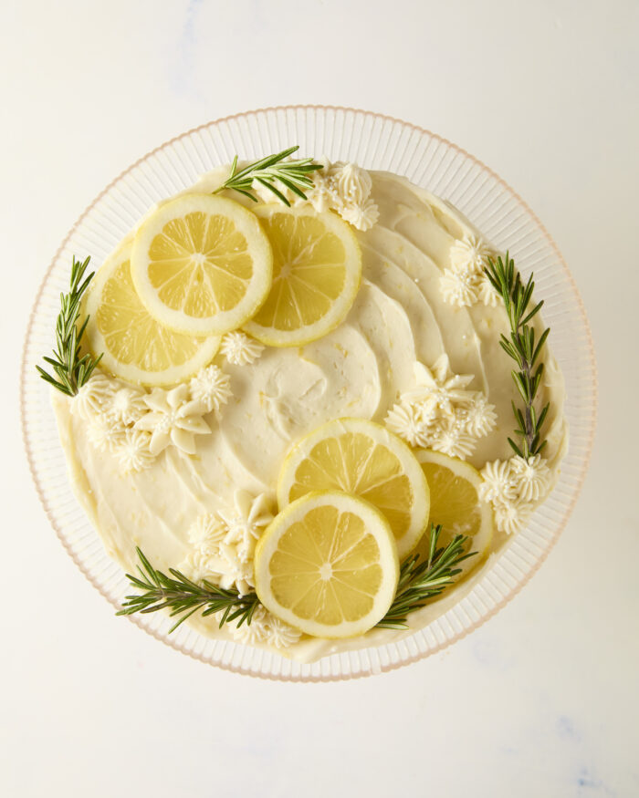 decorated lemon cake with fresh lemon slices and rosemary sprigs