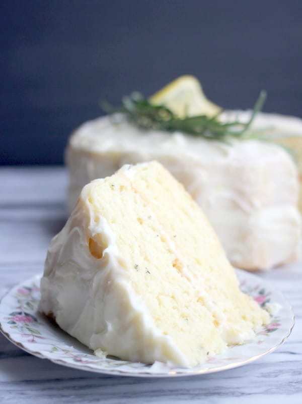 A slice of Fluffy Lemon-Rosemary Cake with Lemon Cream Cheese Frosting