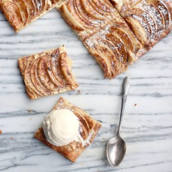 Spiced Rum Apple Cream Cheese Tart cut into squares topped with ice cream