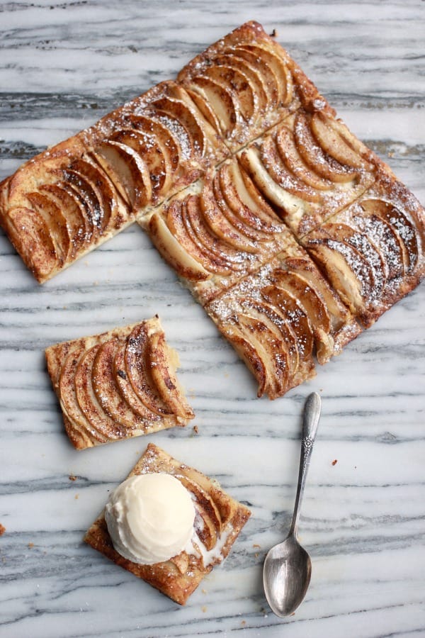 Spiced Rum Apple Tart cut into squares with a spoonful of vanilla ice cream