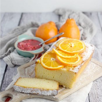 Tangerine Ricotta Pound Cake with a slice taken out with Rhubarb Compote on the side