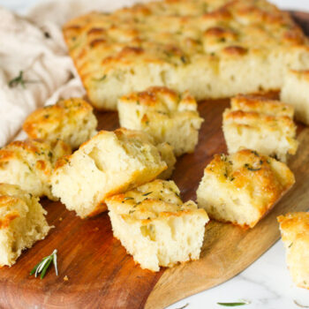 Focaccia bread cut into squares on a wooden board