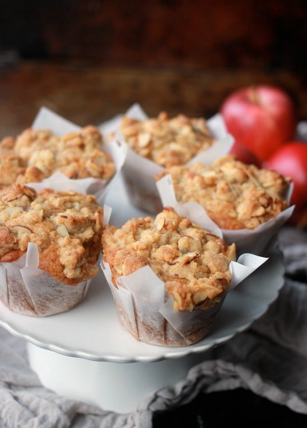 Apple Muffins with Almond Streusel Topping sitting on a cake stand