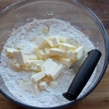 Fat being cut into dry ingredients with pastry cutter