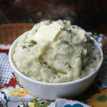 Creamy Herbed Mashed Potatoes in a bowl topped with a pad of butter