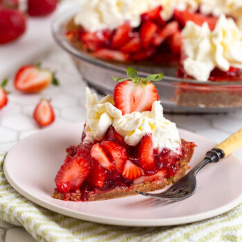 a slice of fresh strawberry jello pie with graham cracker crust with whipped cream on top