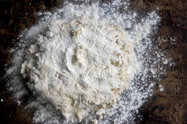 Biscuit dough patted down with extra flour on the counter