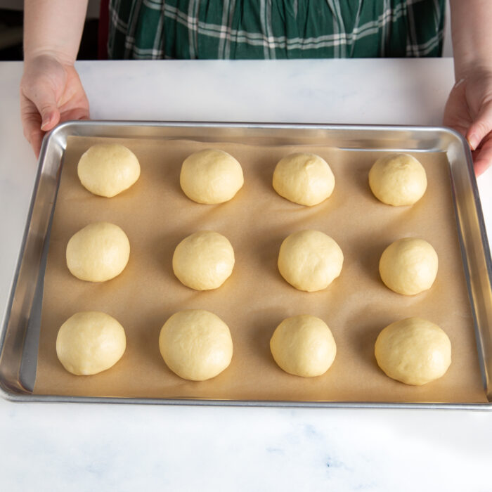 Shaped dinner rolls on a sheet pan.