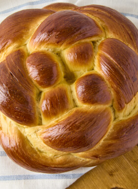 challah bread braided round on a wooden board