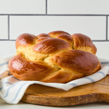 challah bread braided round on a wooden board