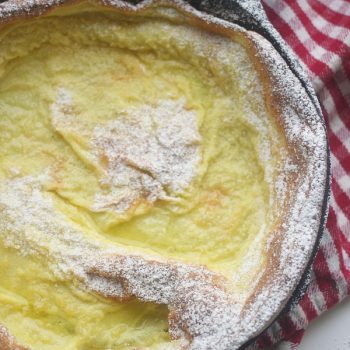 A dutch baby pancake sprinkled with powdered sugar