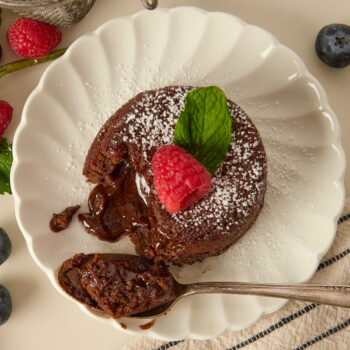 a gooey molten lava cake on a plate with the middle oozing out