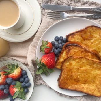 Crispy Oven Baked French Toast slices on a plate with fresh berries