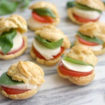 Profiteroles filled with slices of tomato, fresh mozzarella, and basil