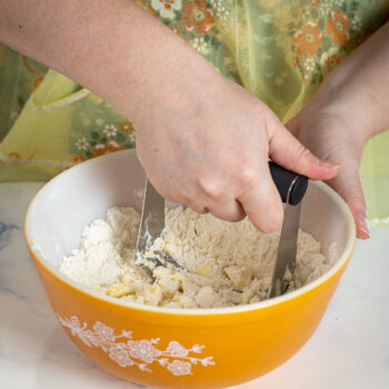 using a pastry cutter to blend cold butter and flour