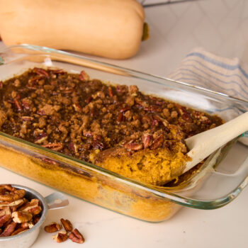 butternut squash casserole being served out of a casserole dish