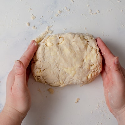 Rough puff pastry dough being pressed into a rectangle