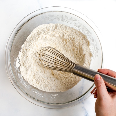 A mixing bowl with the flour and salt being whisked together