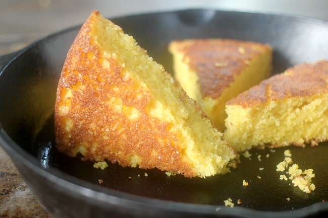 A wedge of cornbread in a skillet