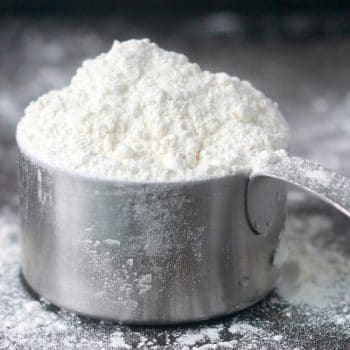 Flour overflowing a measuring cup