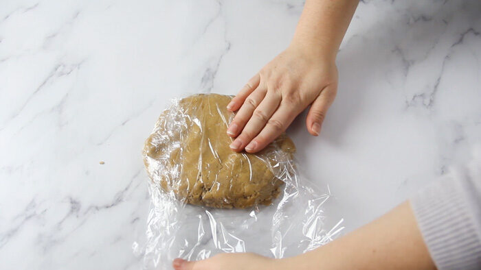 Wrapping peppernut dough in plastic wrap to chill before rolling